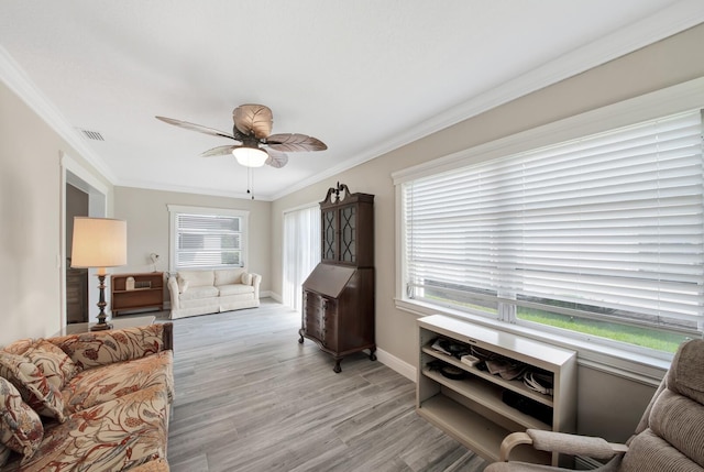 living room with ornamental molding, light hardwood / wood-style floors, and a healthy amount of sunlight