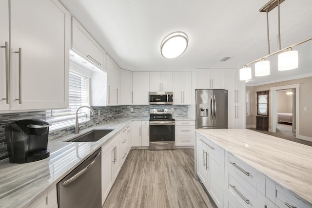 kitchen featuring white cabinets, appliances with stainless steel finishes, and sink