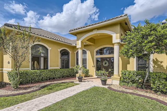 property entrance featuring a lawn