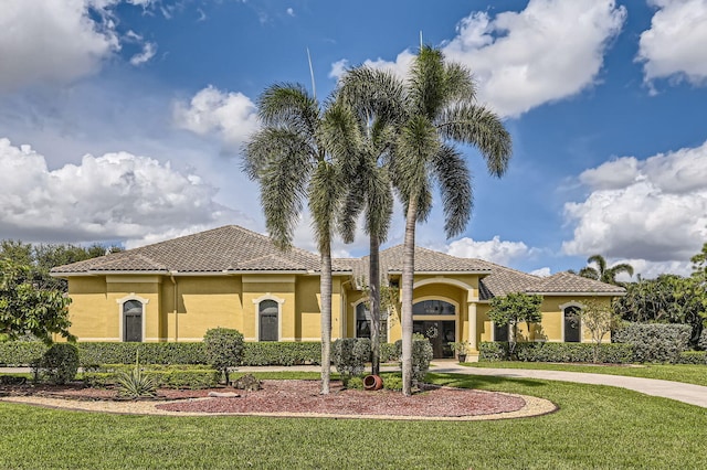 mediterranean / spanish-style home with a front lawn