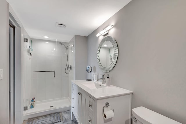 bathroom with tiled shower, vanity, and toilet