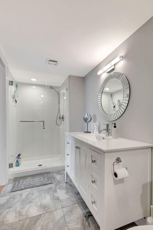 bathroom with vanity and tiled shower