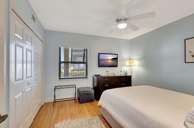 bedroom featuring light hardwood / wood-style floors, ceiling fan, and a closet