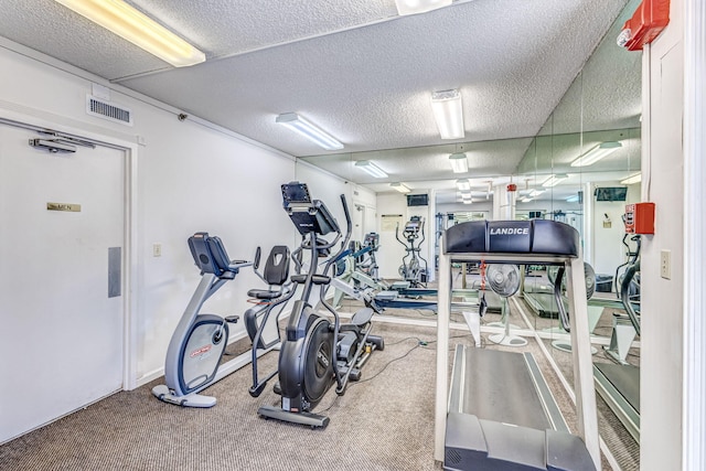 exercise room with carpet flooring and a textured ceiling