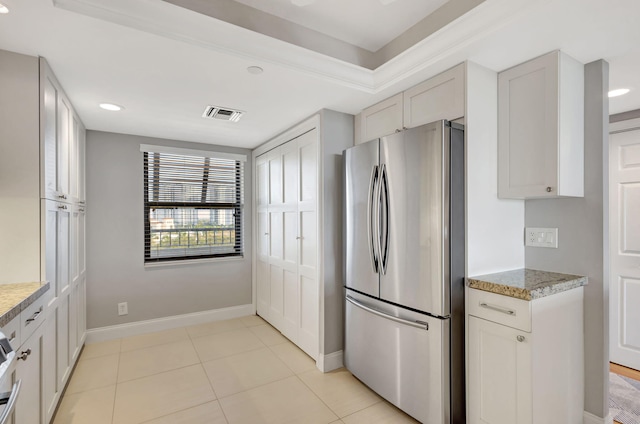 kitchen featuring stainless steel fridge and white cabinets