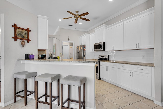 kitchen featuring white cabinetry, crown molding, and stainless steel appliances