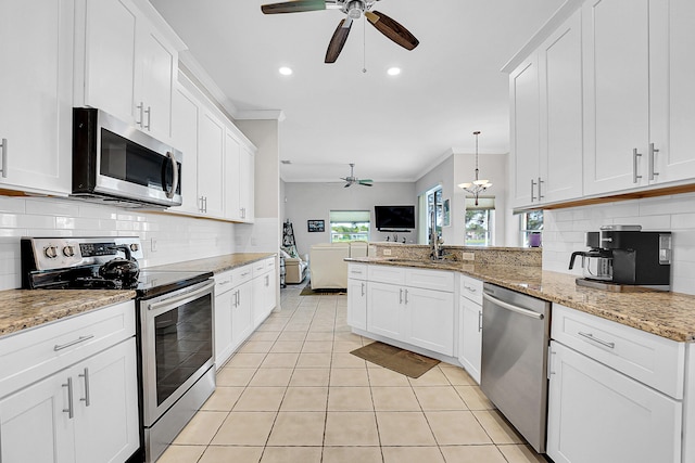 kitchen featuring backsplash, stainless steel appliances, white cabinetry, and ornamental molding