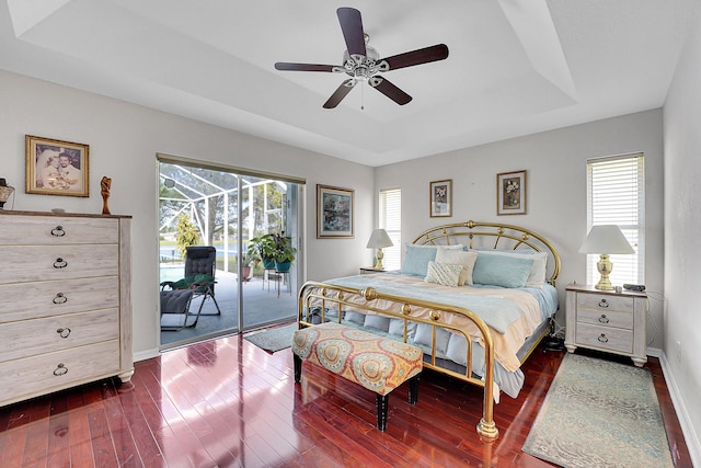 bedroom featuring access to outside, a raised ceiling, ceiling fan, and dark wood-type flooring