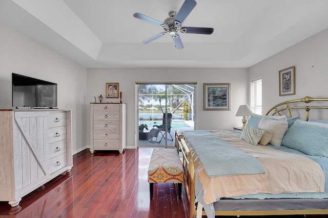 bedroom with access to outside, a raised ceiling, ceiling fan, and dark hardwood / wood-style floors