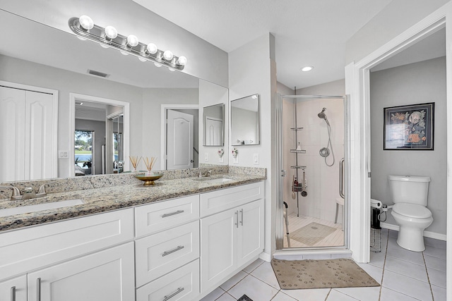 bathroom with tile patterned floors, vanity, toilet, and walk in shower