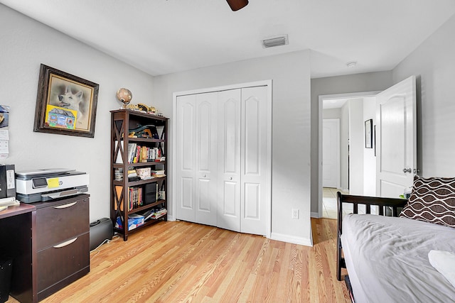 bedroom with light hardwood / wood-style floors, a closet, and ceiling fan