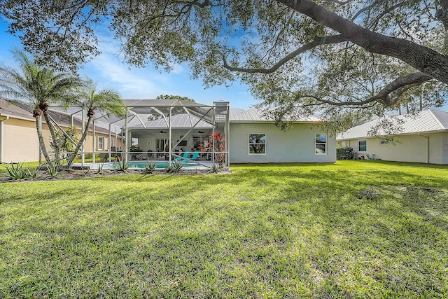 back of house featuring a lanai and a lawn