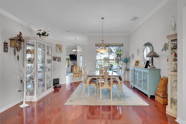 dining room with crown molding and dark wood-type flooring