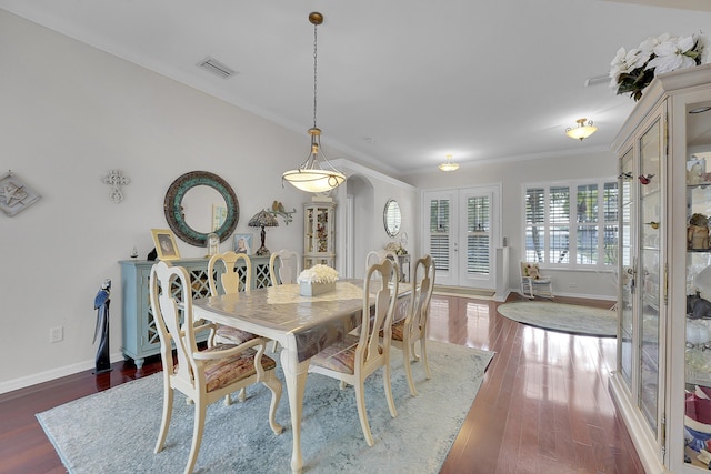 dining area with crown molding and dark wood-type flooring