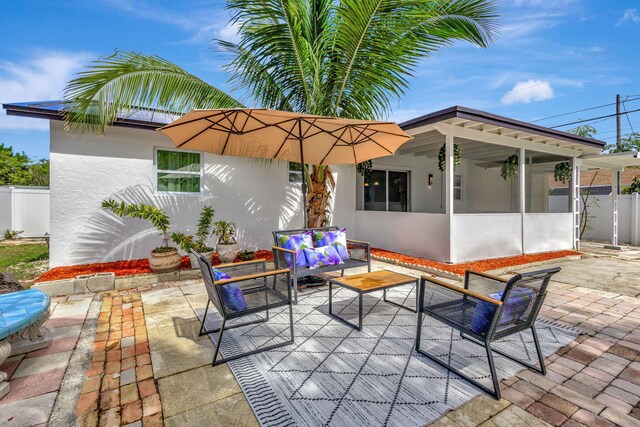 back of property featuring a patio, a yard, and a sunroom