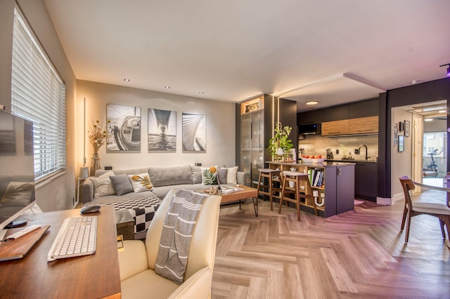 living room with light parquet floors and sink