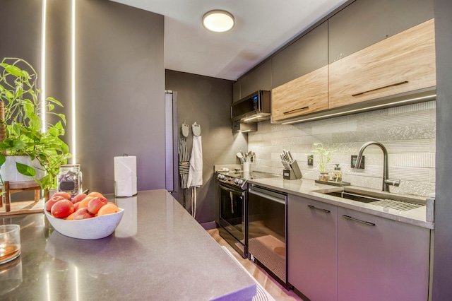 kitchen featuring light stone counters, stainless steel appliances, backsplash, and sink