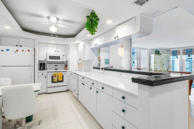1147 Hillsboro Mile Unit 701, Hillsboro Beach, FL 33062 - kitchen with visible vents, a ceiling fan, a peninsula, white appliances, and a sink