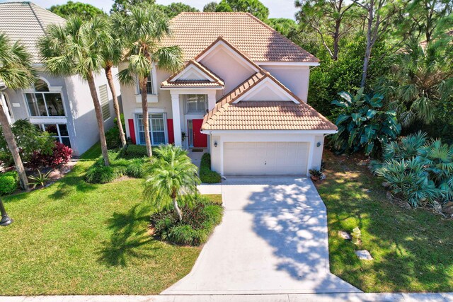 mediterranean / spanish-style home with a front yard and a garage