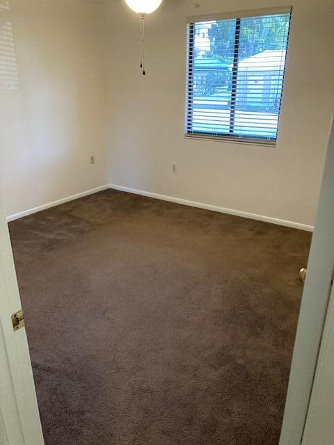 unfurnished room with dark carpet