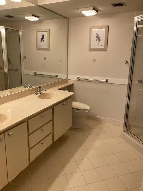 bathroom featuring an enclosed shower, tile patterned floors, vanity, and toilet