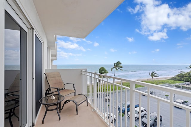 balcony featuring a water view and a beach view