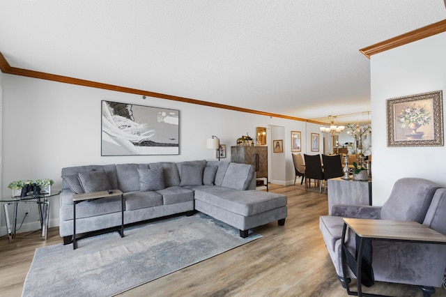 living room featuring ornamental molding, a chandelier, light wood-type flooring, and a textured ceiling