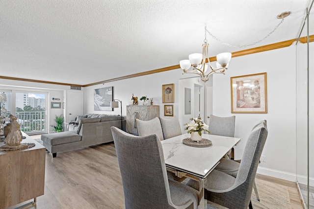 dining space with light hardwood / wood-style flooring, a textured ceiling, and crown molding