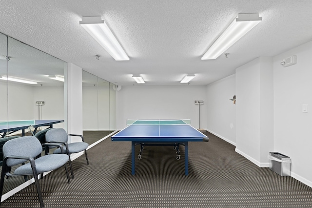 rec room featuring a textured ceiling and dark colored carpet