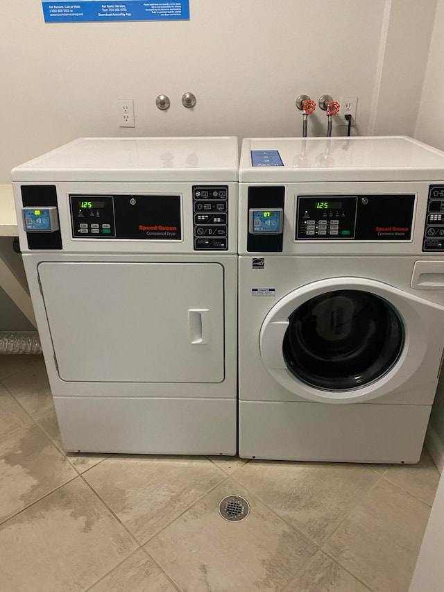 washroom featuring washing machine and dryer and light tile patterned flooring