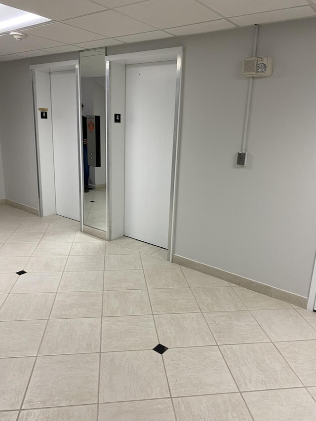 3301 S Ocean Blvd Unit 405, Highland Beach, FL 33487 - unfurnished room with elevator, light tile patterned floors, a drop ceiling, baseboards, and a smoke detector