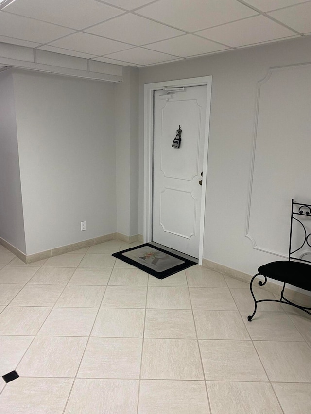 entrance foyer featuring a paneled ceiling and light tile patterned floors