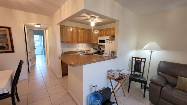 kitchen with white appliances, kitchen peninsula, light tile patterned floors, and ceiling fan