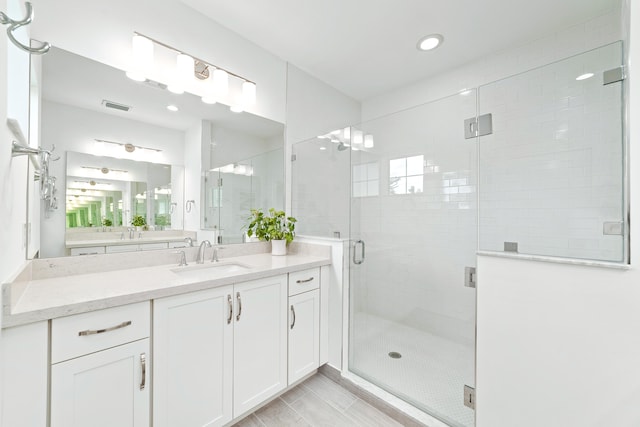 bathroom with vanity and a shower with door