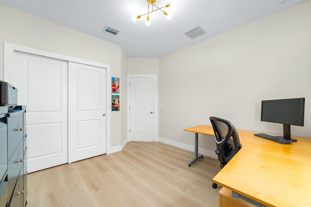 home office with an inviting chandelier and light hardwood / wood-style floors