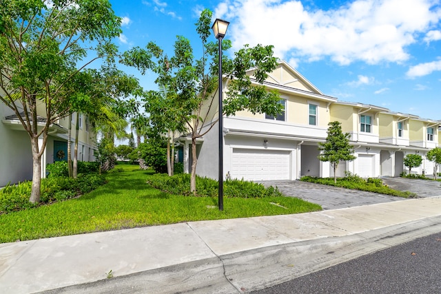 multi unit property with a balcony, a garage, and a front lawn