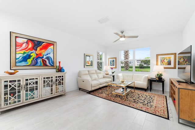 living room with ceiling fan and light hardwood / wood-style floors