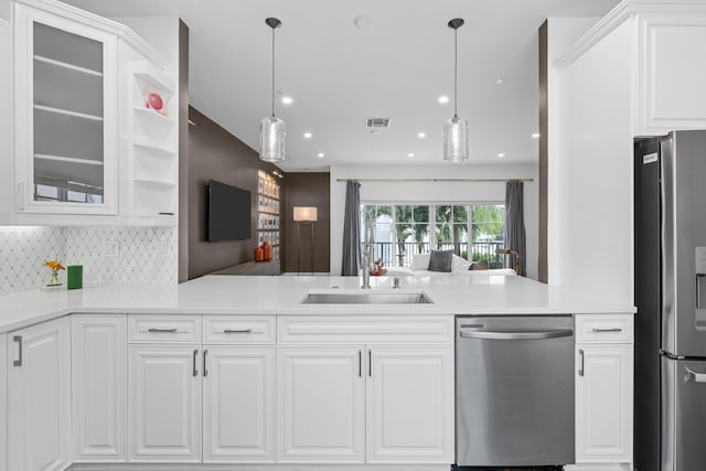 kitchen featuring appliances with stainless steel finishes, hanging light fixtures, and white cabinets