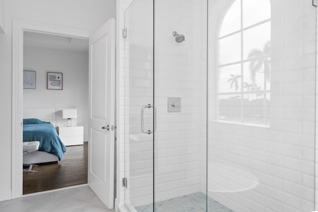 bathroom with a shower with door and wood-type flooring