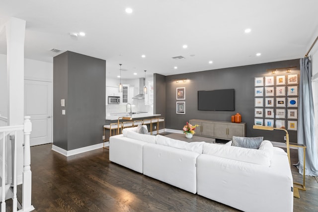 living room with dark wood-type flooring and sink