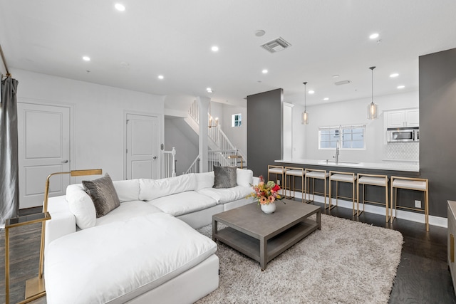 living room featuring dark wood-type flooring and sink