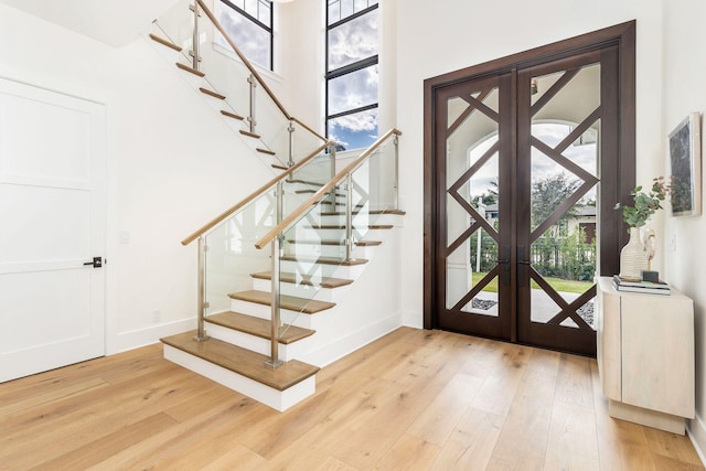 entrance foyer featuring light hardwood / wood-style floors, french doors, and a healthy amount of sunlight