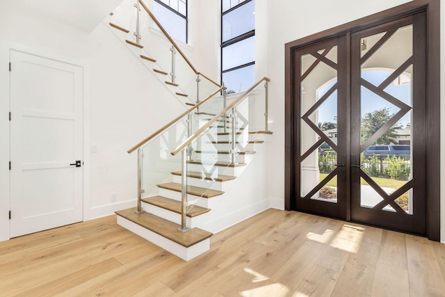 foyer with light wood-type flooring and french doors