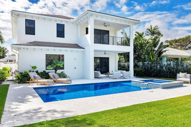 back of house featuring a pool with hot tub, a patio area, a balcony, and ceiling fan