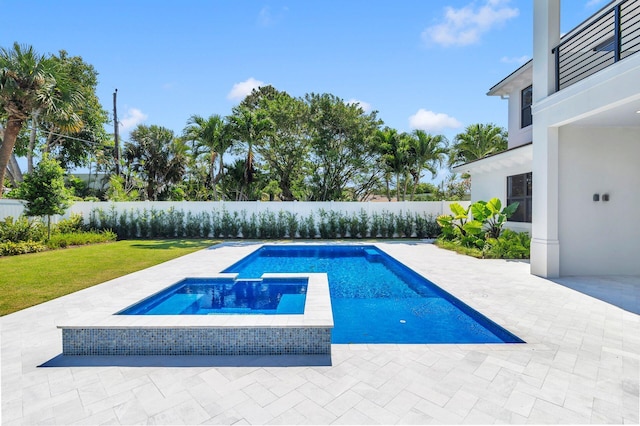 view of pool with an in ground hot tub, a patio area, and a lawn