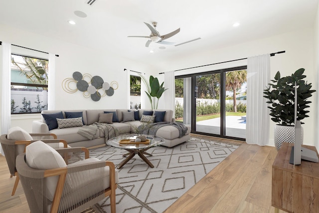 living room with ceiling fan and light hardwood / wood-style floors