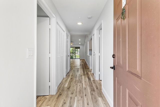 corridor with light hardwood / wood-style floors