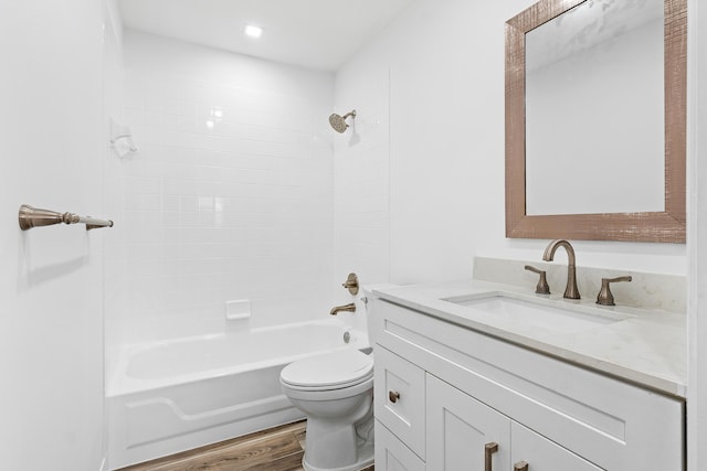 full bathroom with hardwood / wood-style floors, tiled shower / bath combo, vanity, and toilet