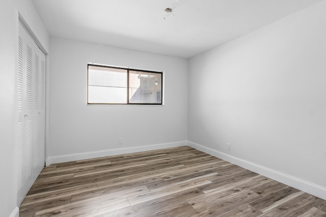 unfurnished bedroom with wood-type flooring and a closet