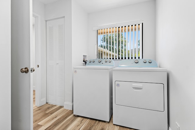 laundry area featuring washer and clothes dryer and light hardwood / wood-style floors